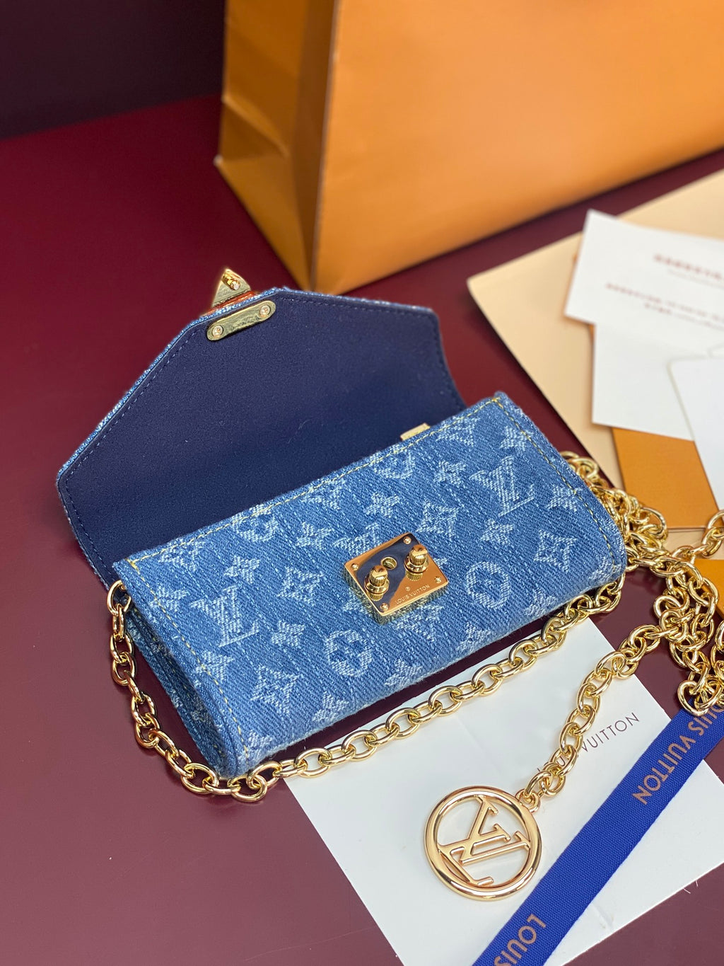 Blue monogram canvas mini bag with gold chain strap and flap closure