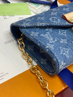 Close-up of blue monogram mini bag with gold chain and front flap