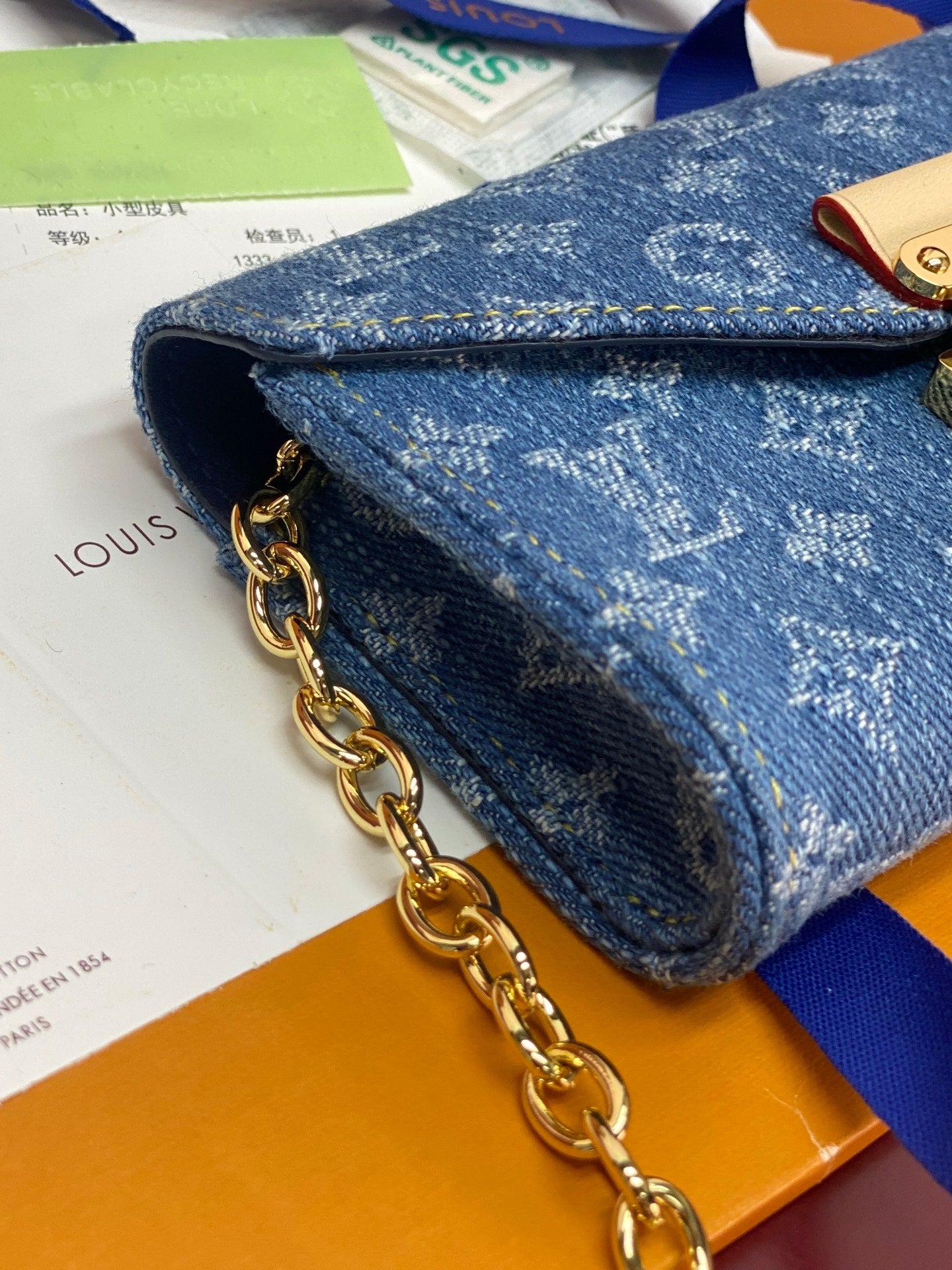 Close-up of blue monogram mini bag with gold chain and front flap