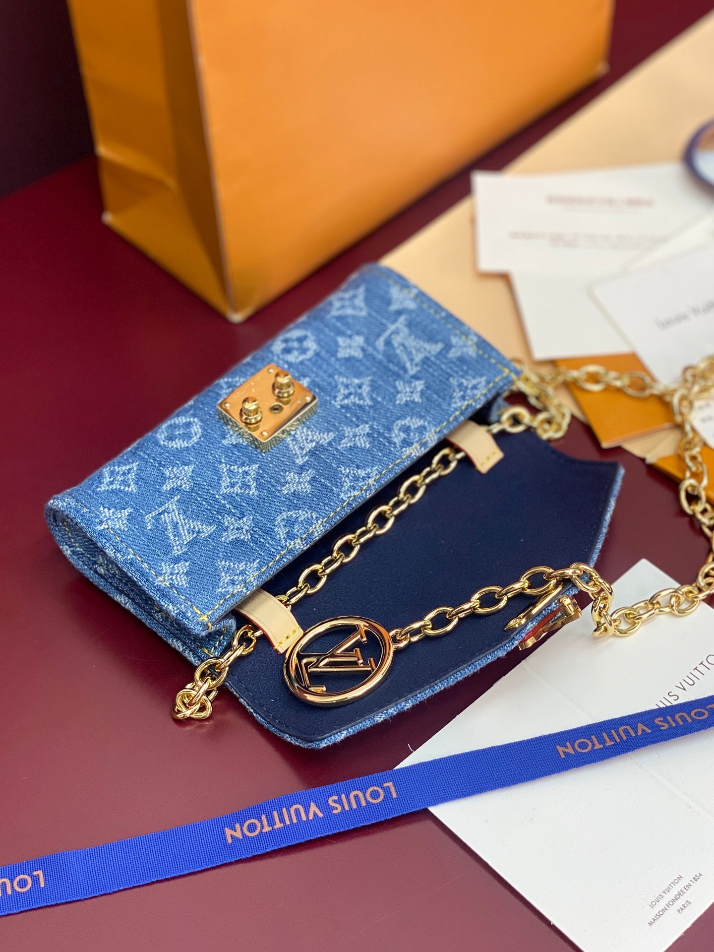 Blue monogram canvas mini bag with gold chain strap and flap closure