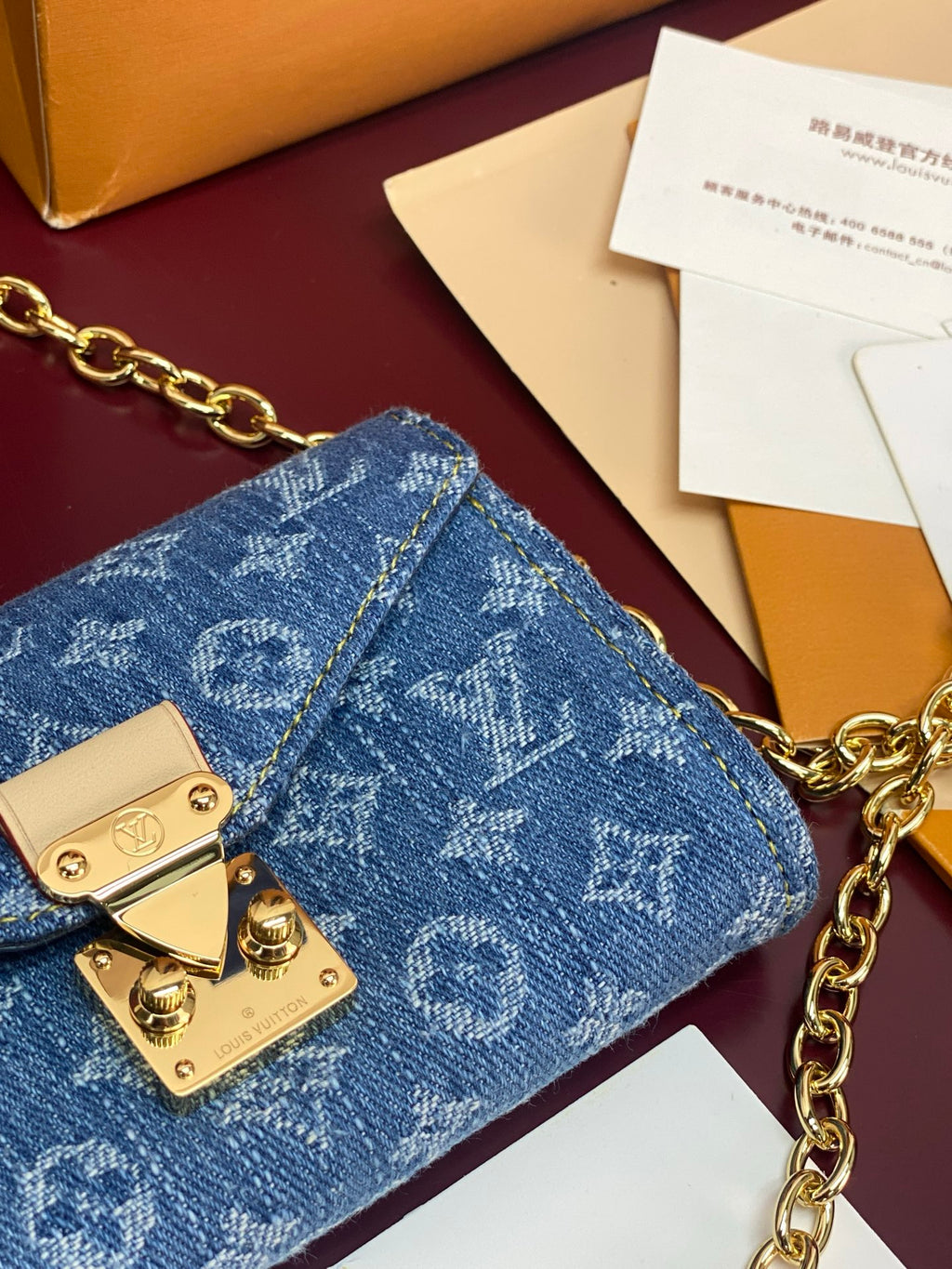 Blue monogram flap bag corner view with gold clasp and chain hardware