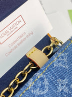 Louis Vuitton small bag tag and gold chain on blue denim
