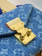 Close-up of gold flap lock on blue monogram canvas mini bag