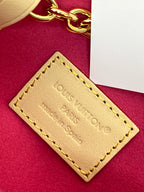 Louis Vuitton bag leather label with gold stitching on red suede