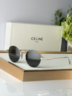 Celine round glasses with gold metal frame and dark lenses, angled front