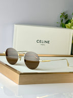 Celine round glasses with gold metal frame and dark lenses on display