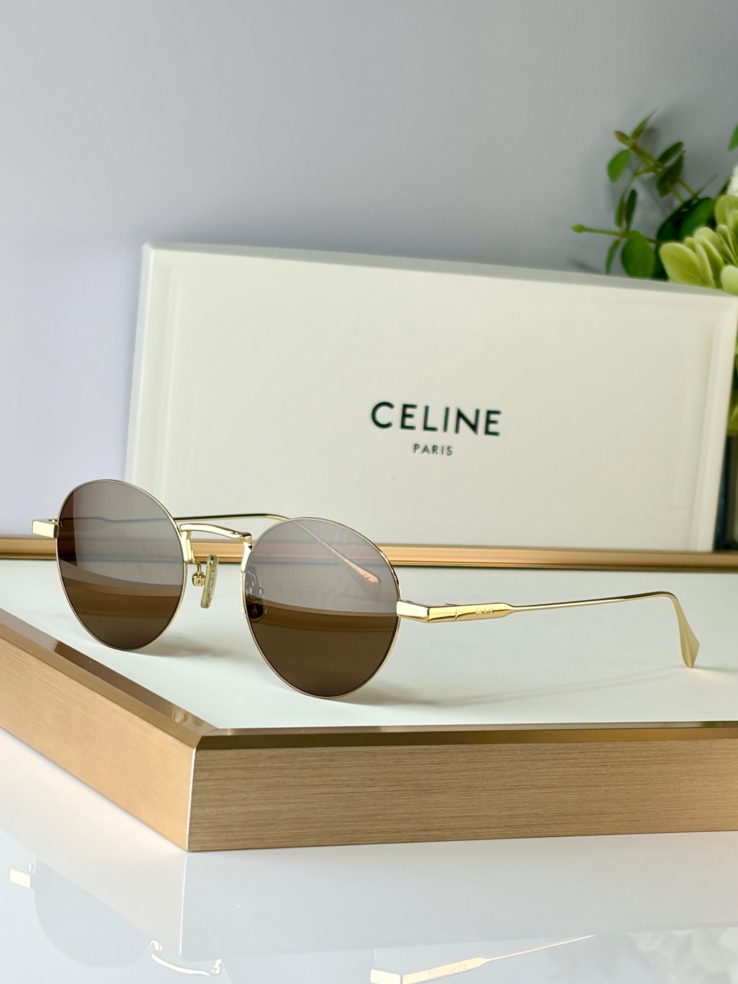 Celine round glasses with gold metal frame and dark lenses on display