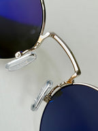 Celine round glasses close-up with gold frame and dark tinted lenses