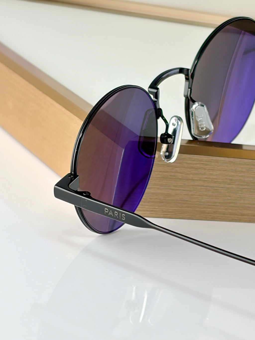 Round sunglasses with black frames and purple-tinted lenses