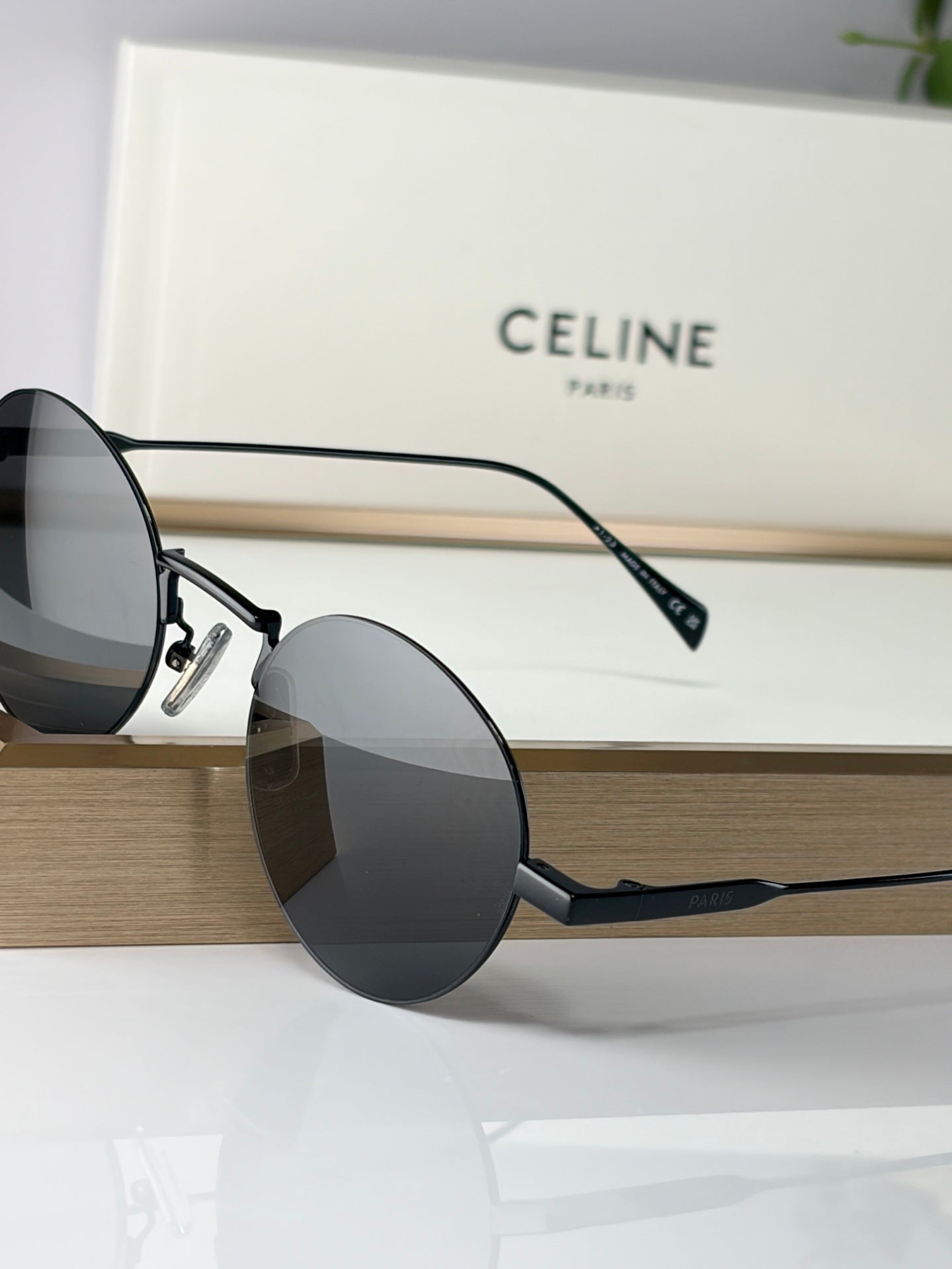 Round sunglasses with black frames and dark lenses, side view