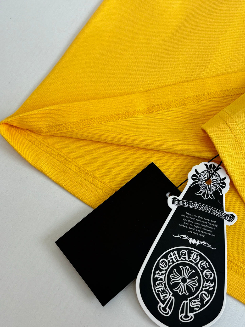 Yellow T-shirt fabric folded with hang tag and label near hem