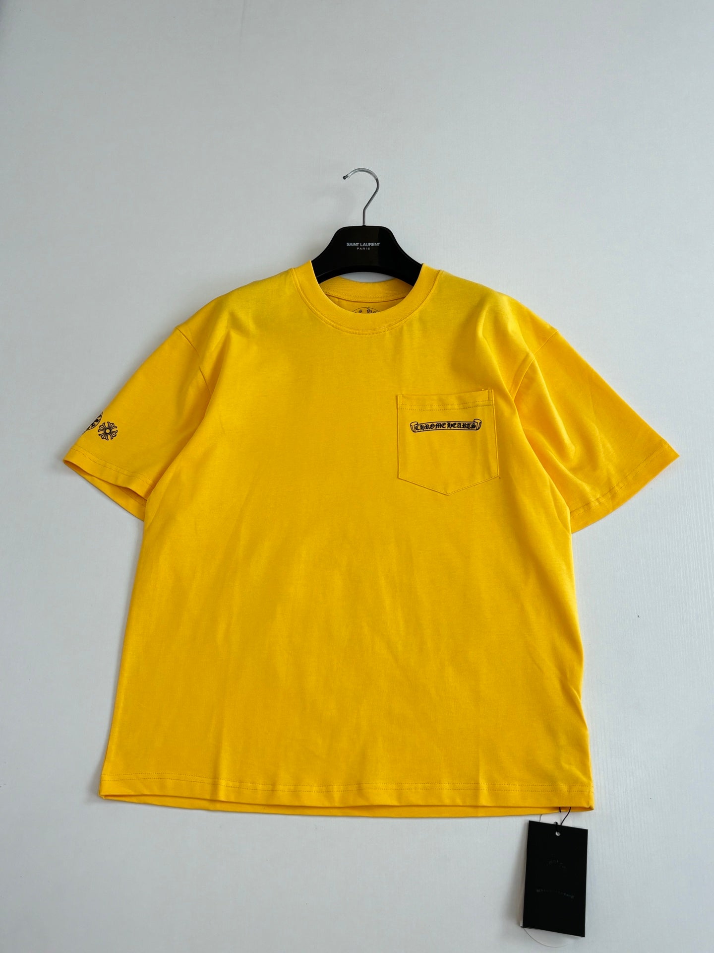 Yellow short-sleeve T-shirt with chest pocket detail and logo patch