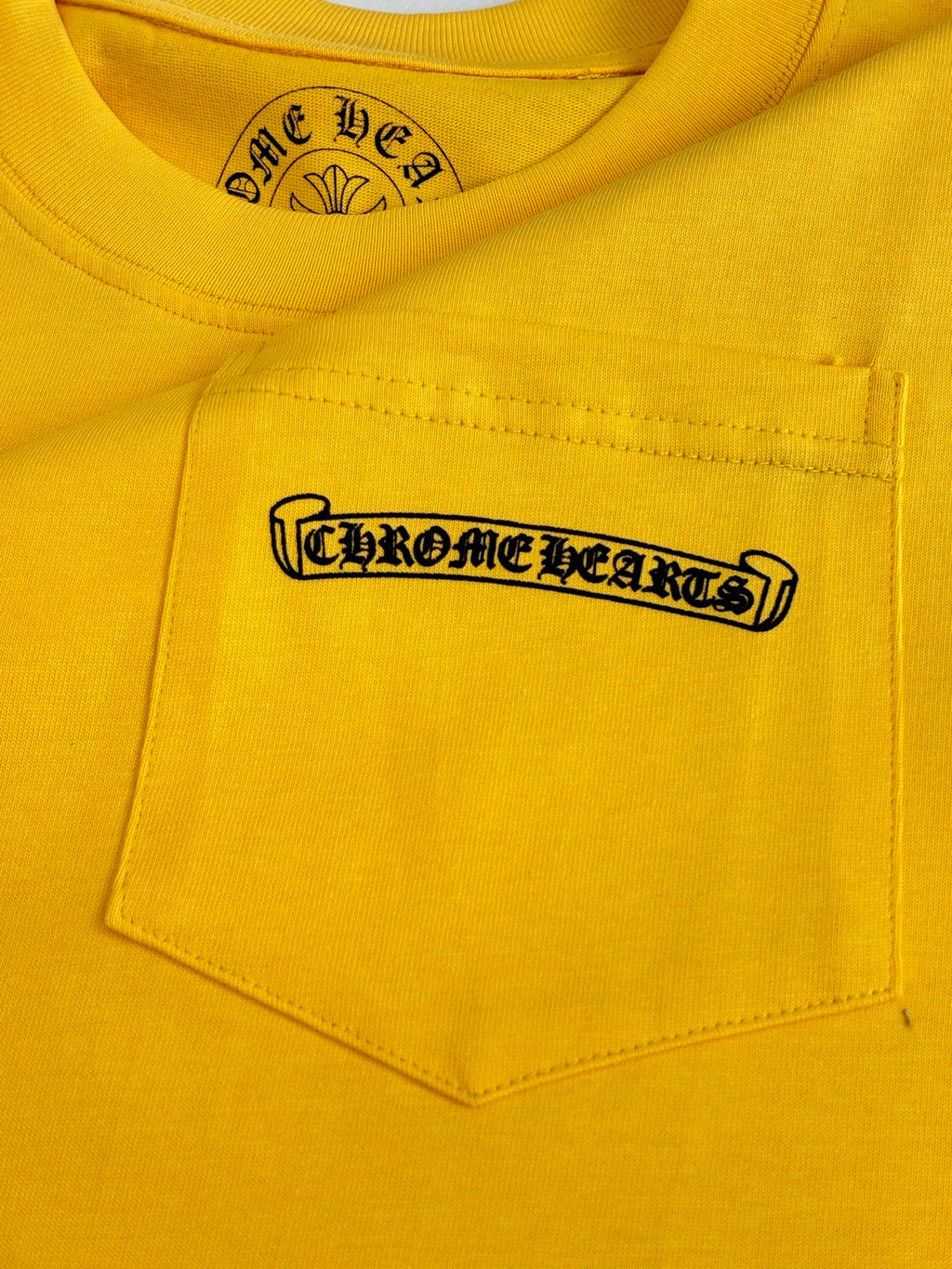 Yellow T-shirt chest pocket with black logo patch