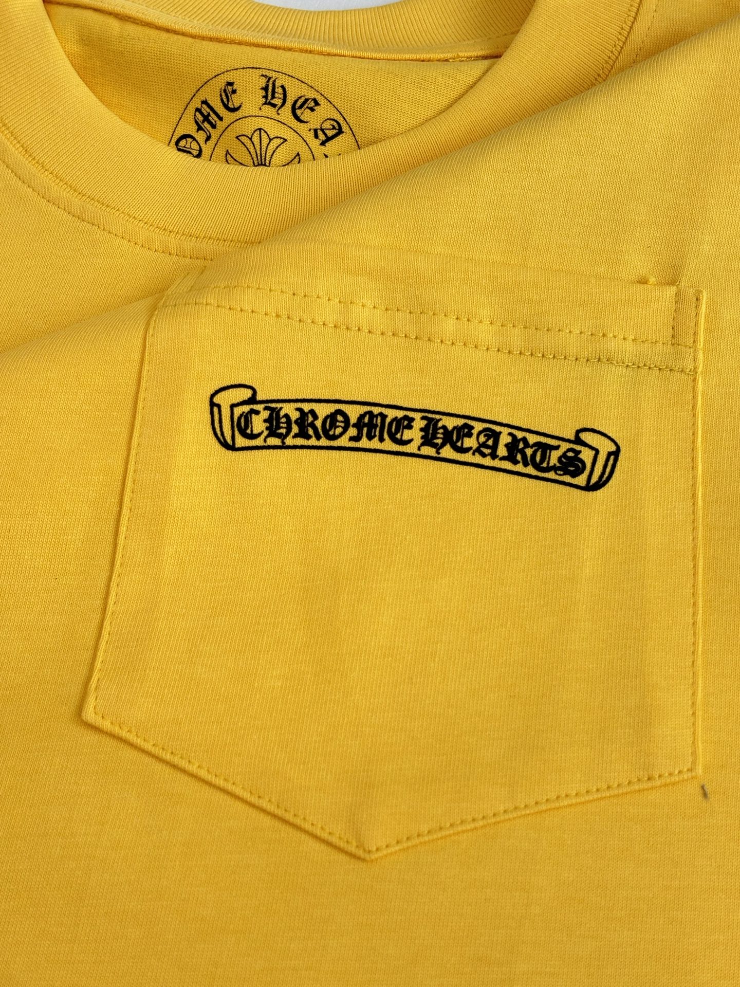Yellow T-shirt chest pocket with black logo patch