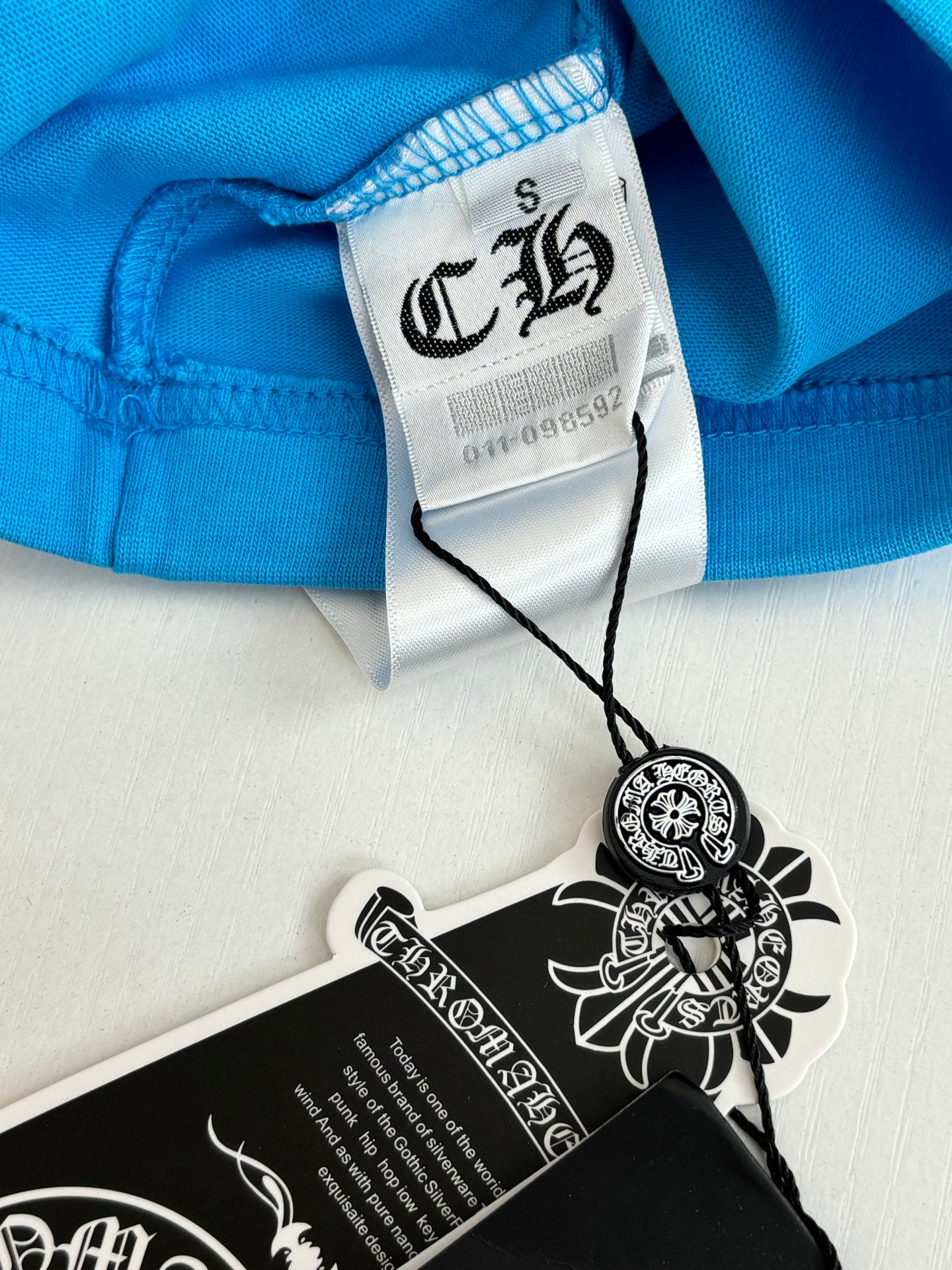 Blue T-shirt hem with tag attached and printed size label