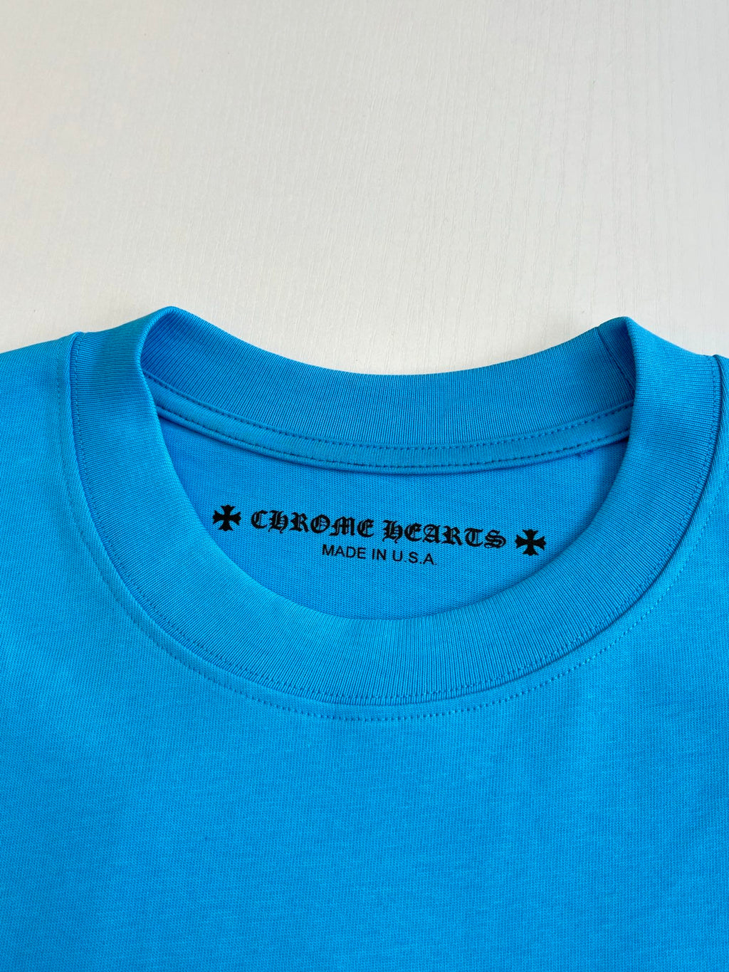 Blue crew-neck T-shirt with printed collar logo text