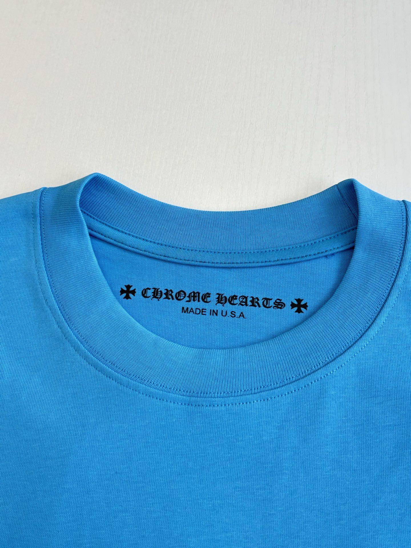 Blue crew-neck T-shirt with printed collar logo text