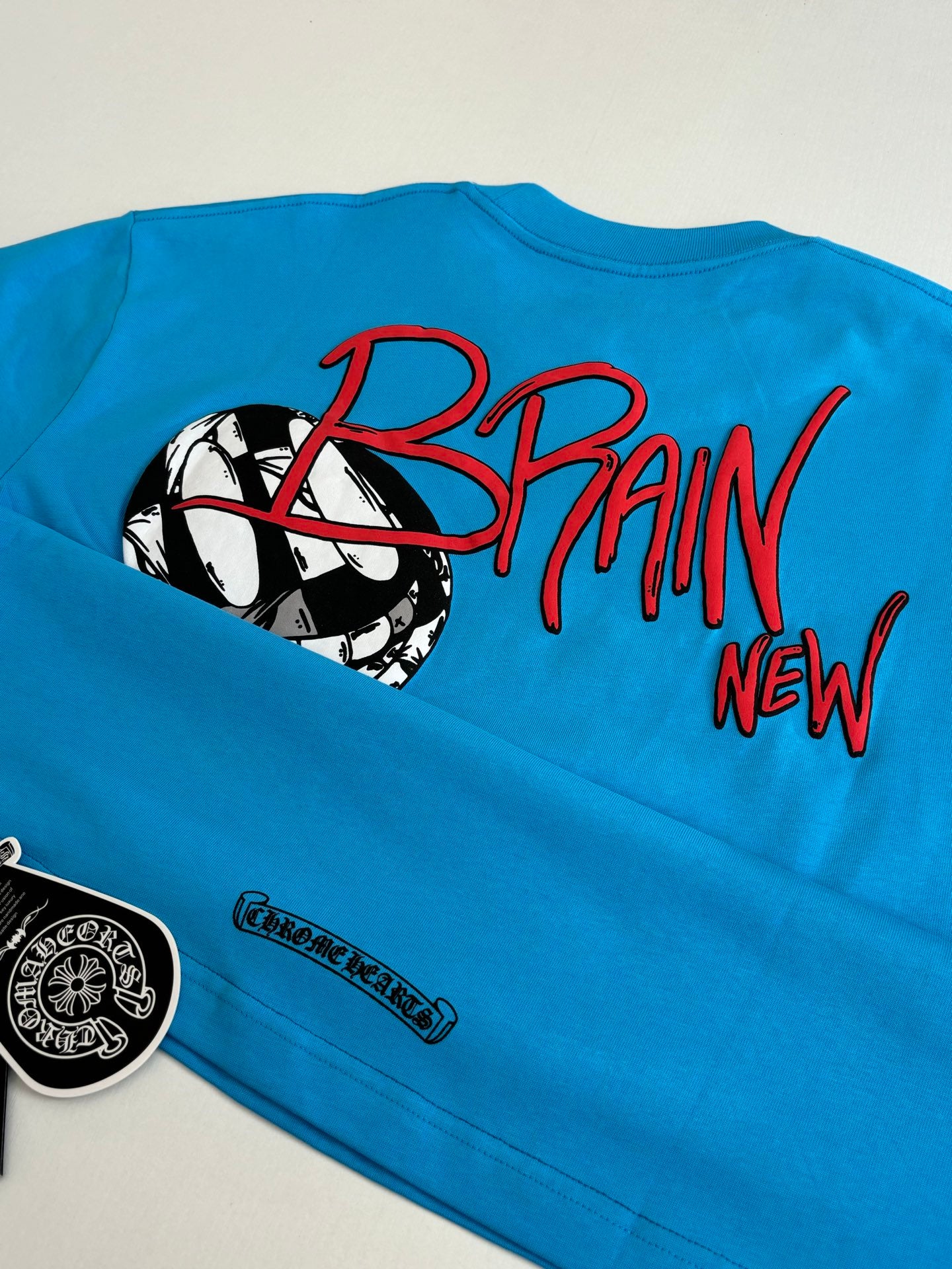 Blue T-shirt sleeve and back print featuring “BRAIN” text