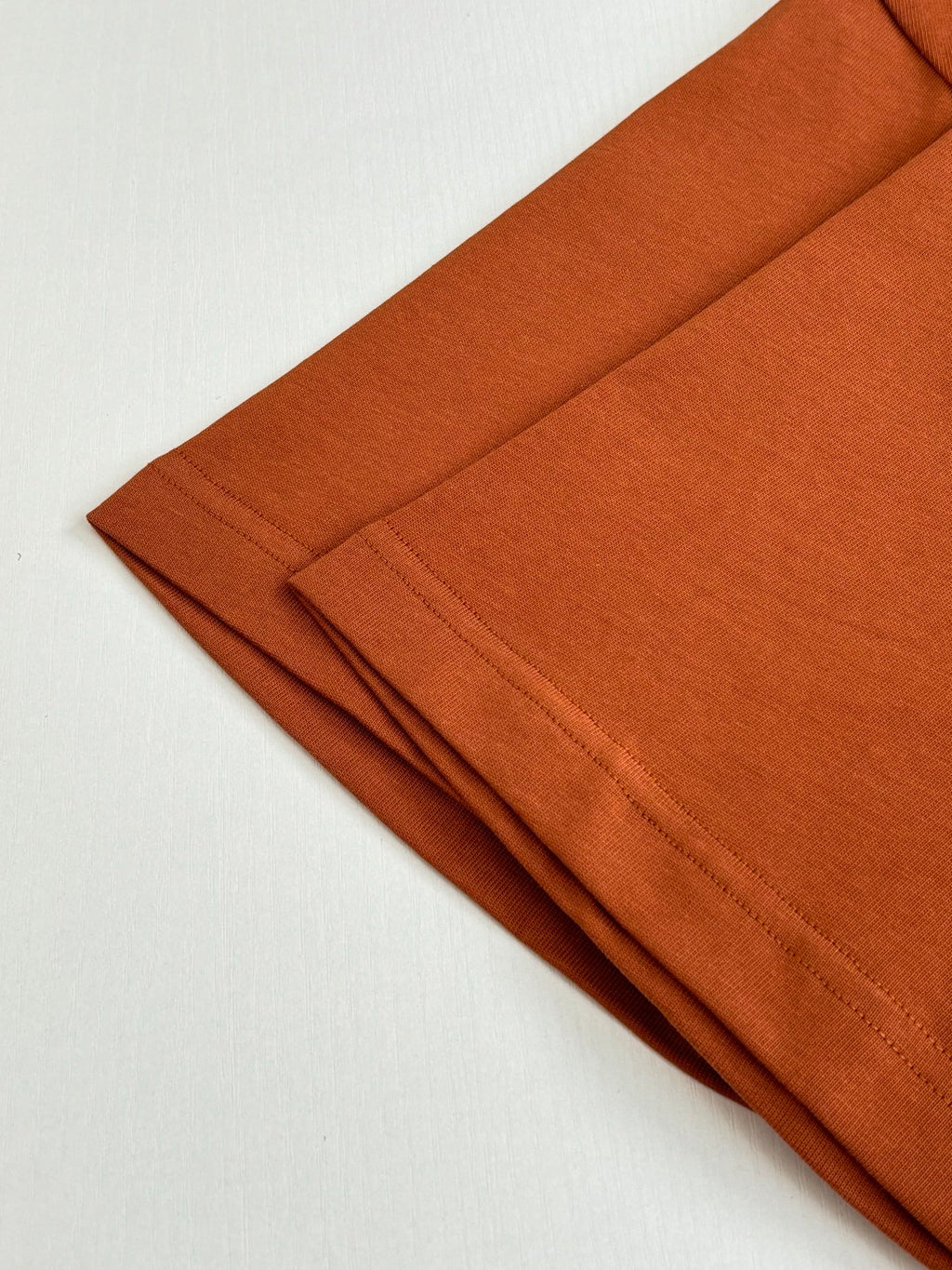 Folded orange short-sleeve T-shirts in a stack
