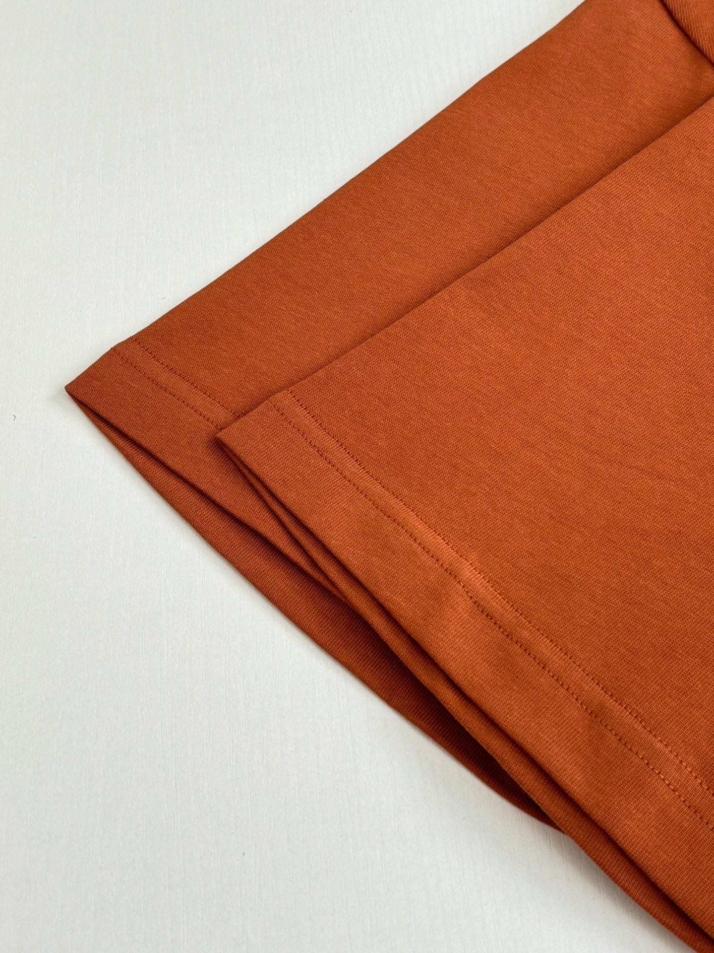 Folded orange short-sleeve T-shirts in a stack
