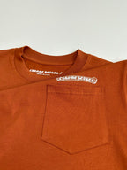 Orange T-shirt front pocket with small printed logo label detail