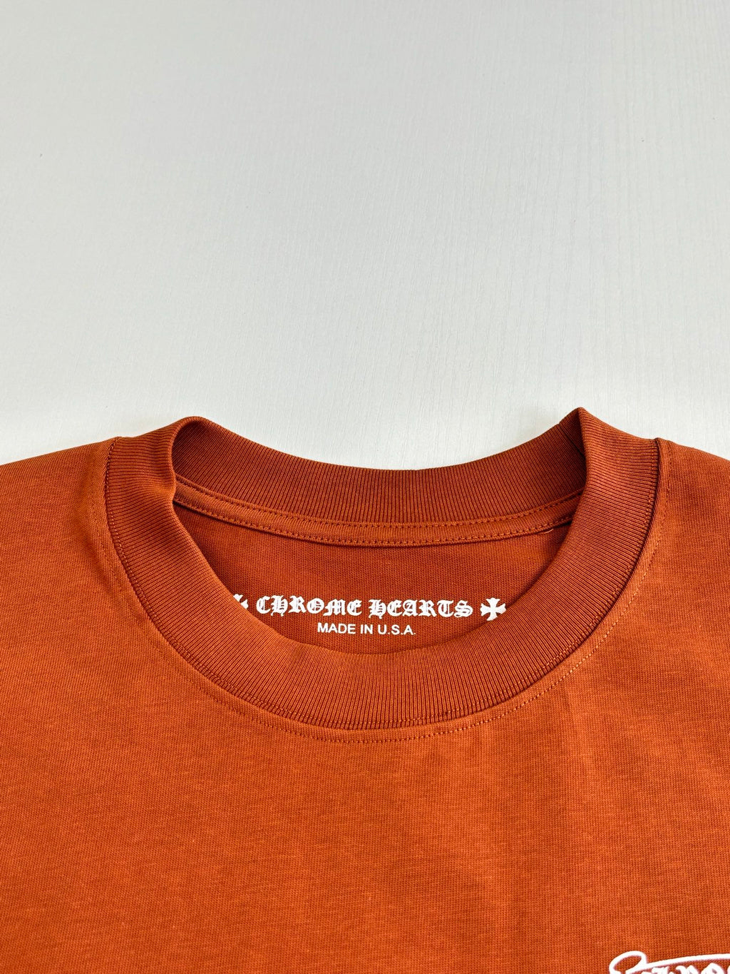 Orange crew-neck T-shirt with printed interior neckline text and Made in USA
