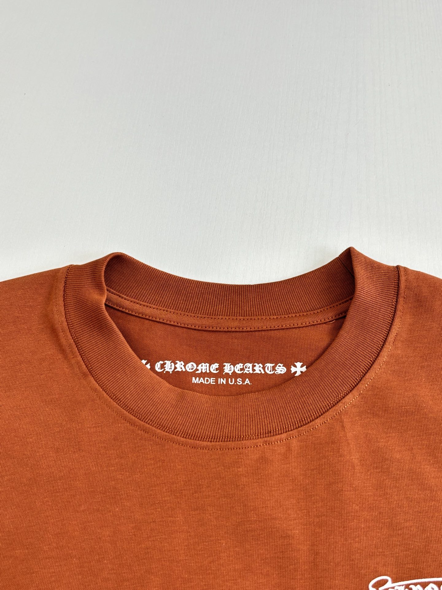 Orange crew-neck T-shirt with printed interior neckline text and Made in USA