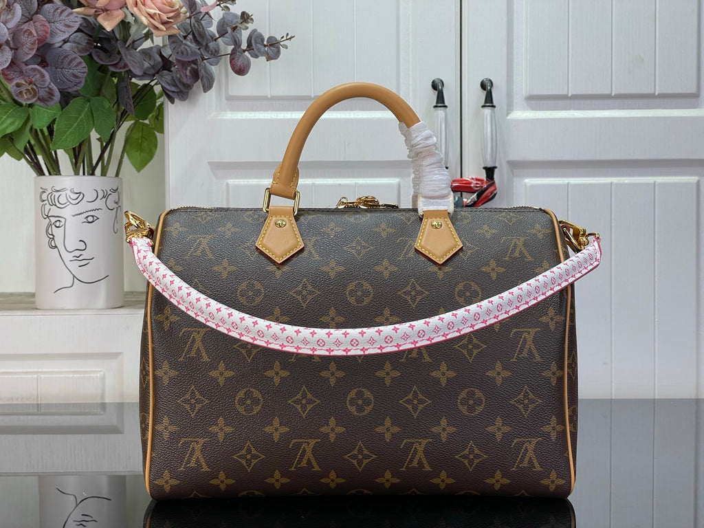 Louis Vuitton monogram handbag with tan handles and pink-trimmed front opening