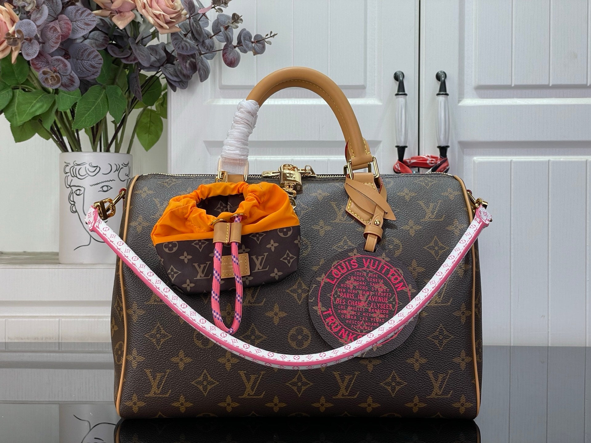 Louis Vuitton monogram handbag with tan handles and pink-trimmed top edge