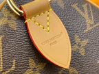 Louis Vuitton leather strap label with red edge trim on monogram handbag