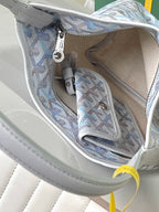 Open interior of light blue monogram bag with side pocket and zipper pull ring