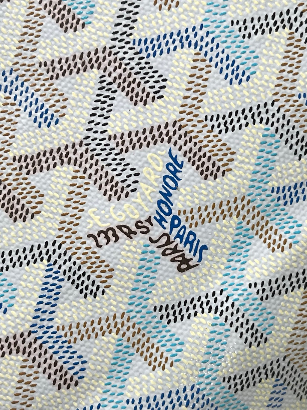 Close-up of light blue-and-white monogram fabric with embroidered text detail