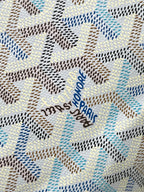 Close-up of light blue-and-white monogram fabric with embroidered text detail
