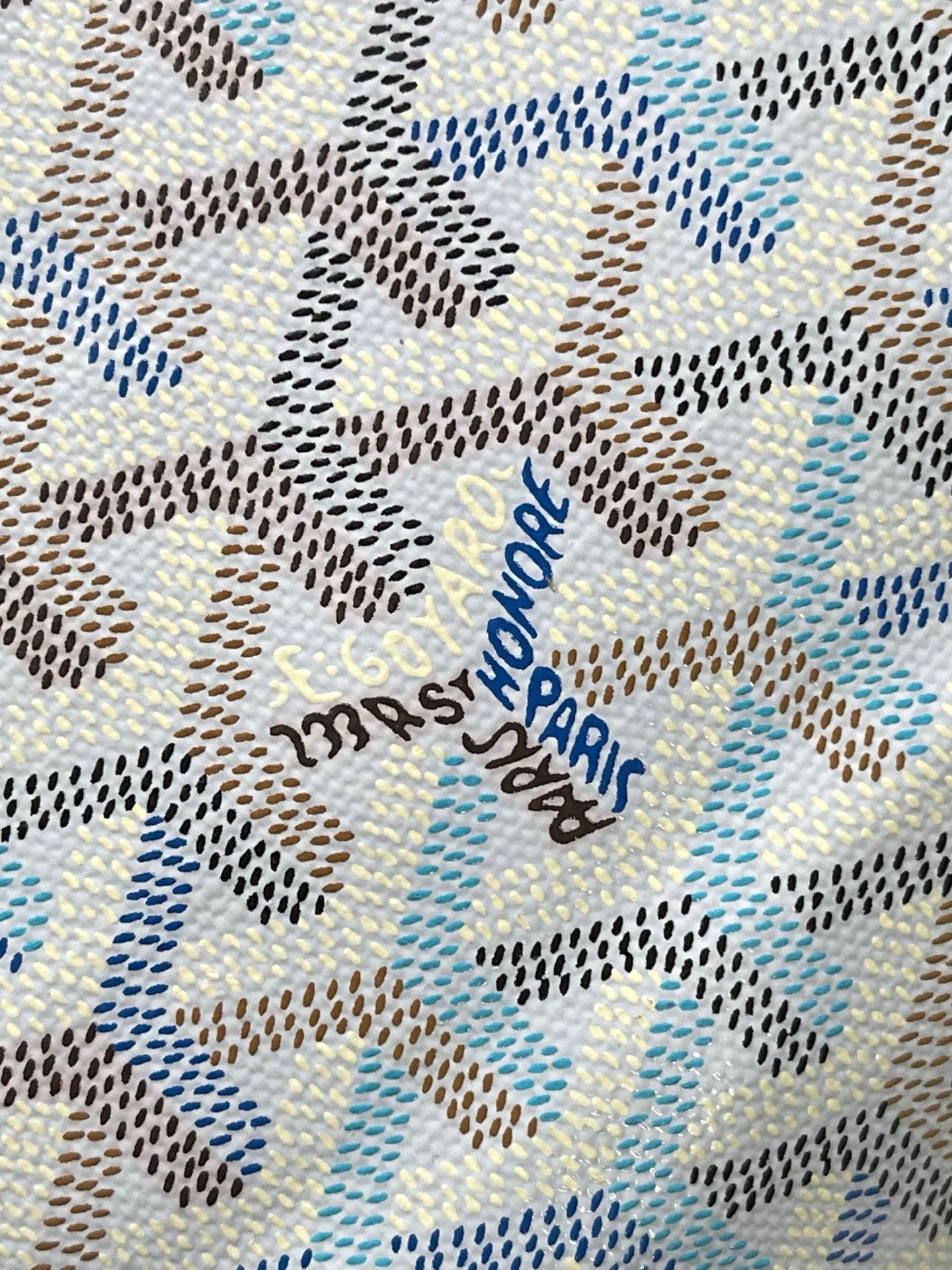 Close-up of light blue-and-white monogram fabric with embroidered text detail