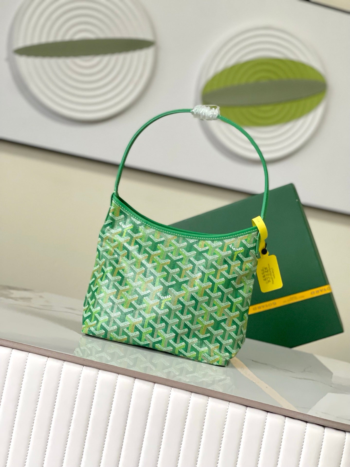 Green patterned bag with top handle loop and fabric-lined front pocket.