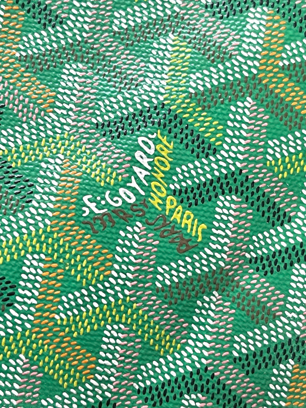 Green patterned fabric with repeating arrow-like motif and small lettering.