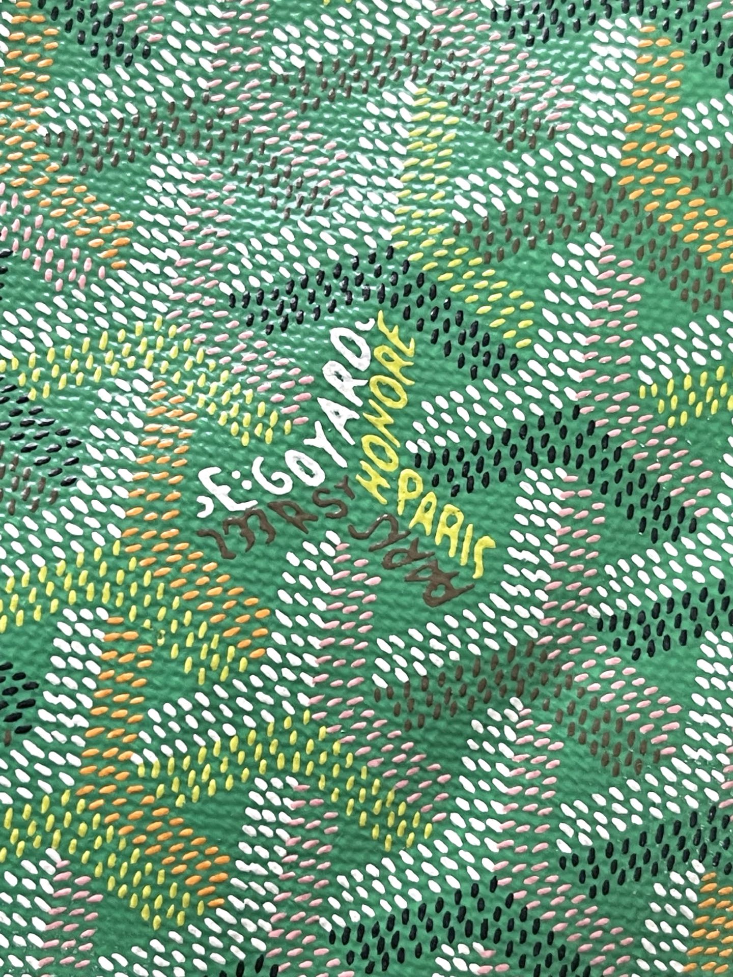 Green patterned fabric with repeating arrow-like motif and small lettering.