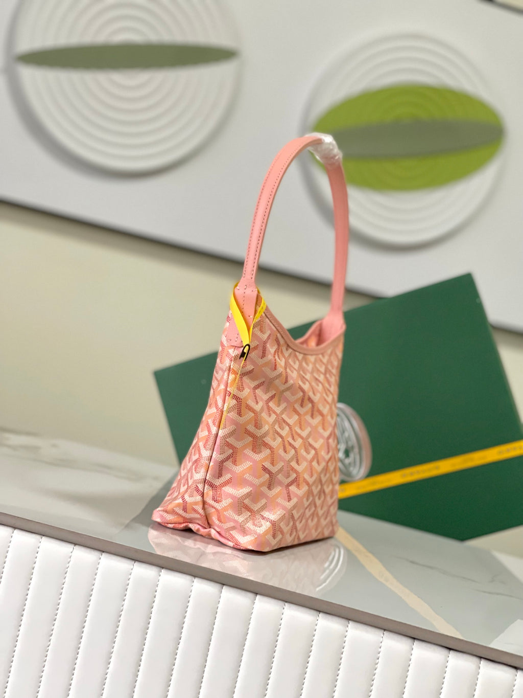 Goyard pink patterned bag with single strap handle and yellow brand tag