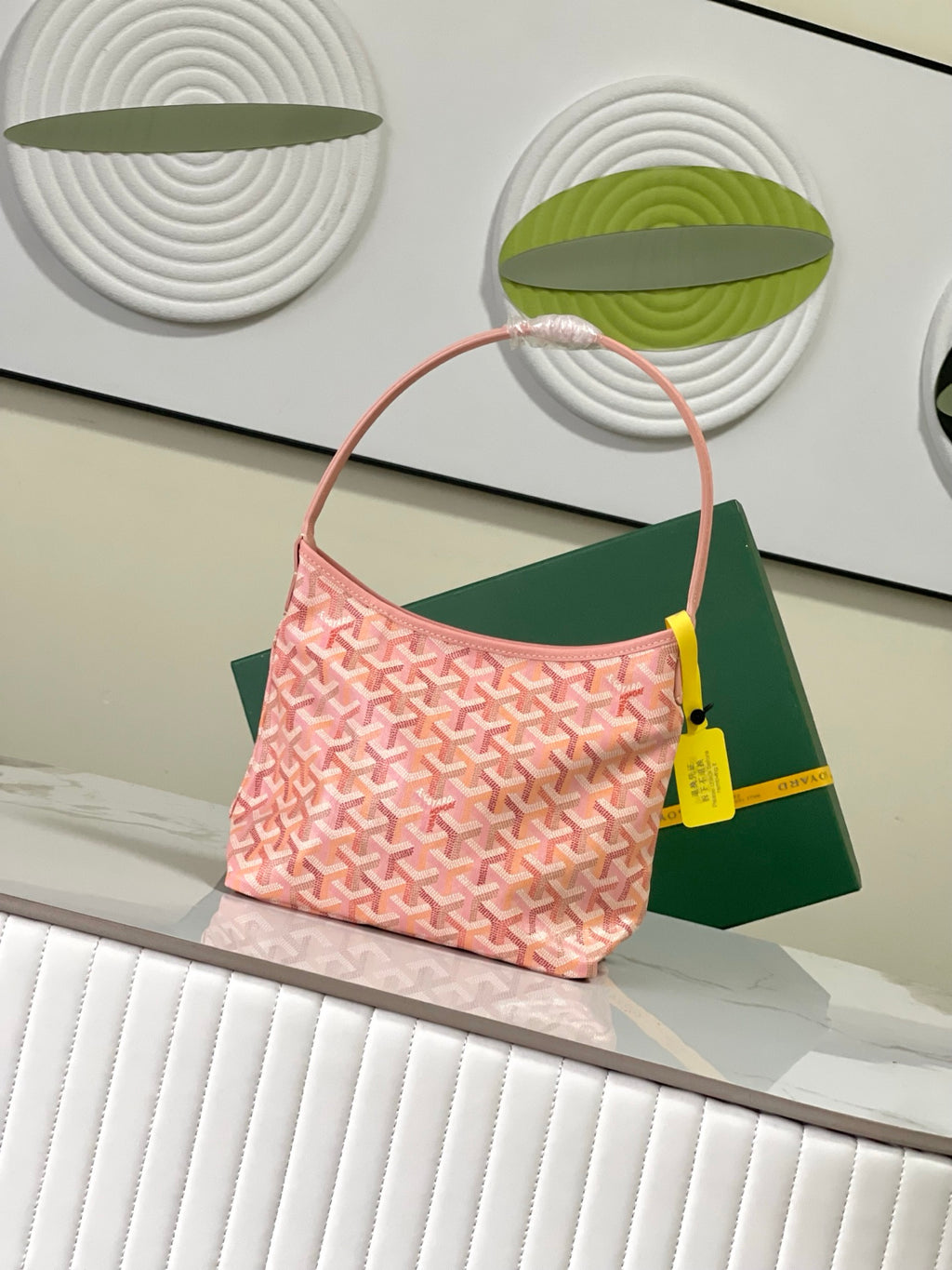 Goyard pink patterned tote bag with curved handles and yellow charm tag