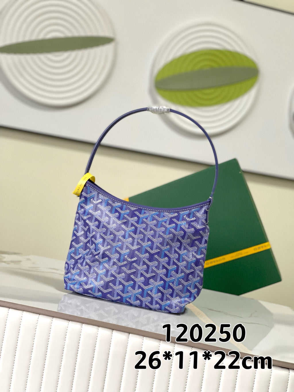 Goyard patterned hobo bag with blue print, rounded handle, and yellow detail tab