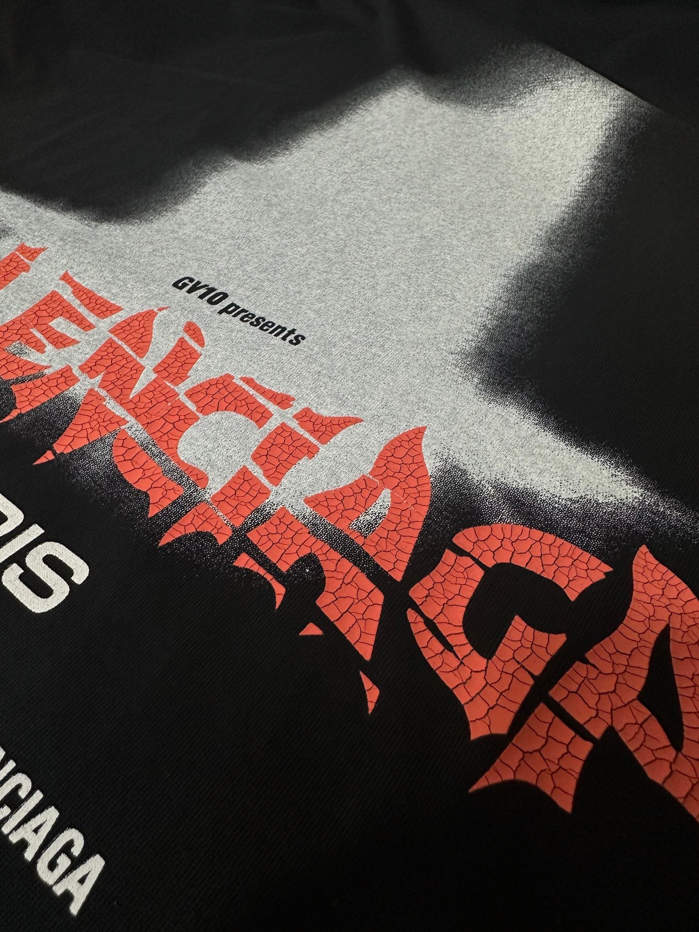 Black T-shirt close-up of red logo lettering and small text