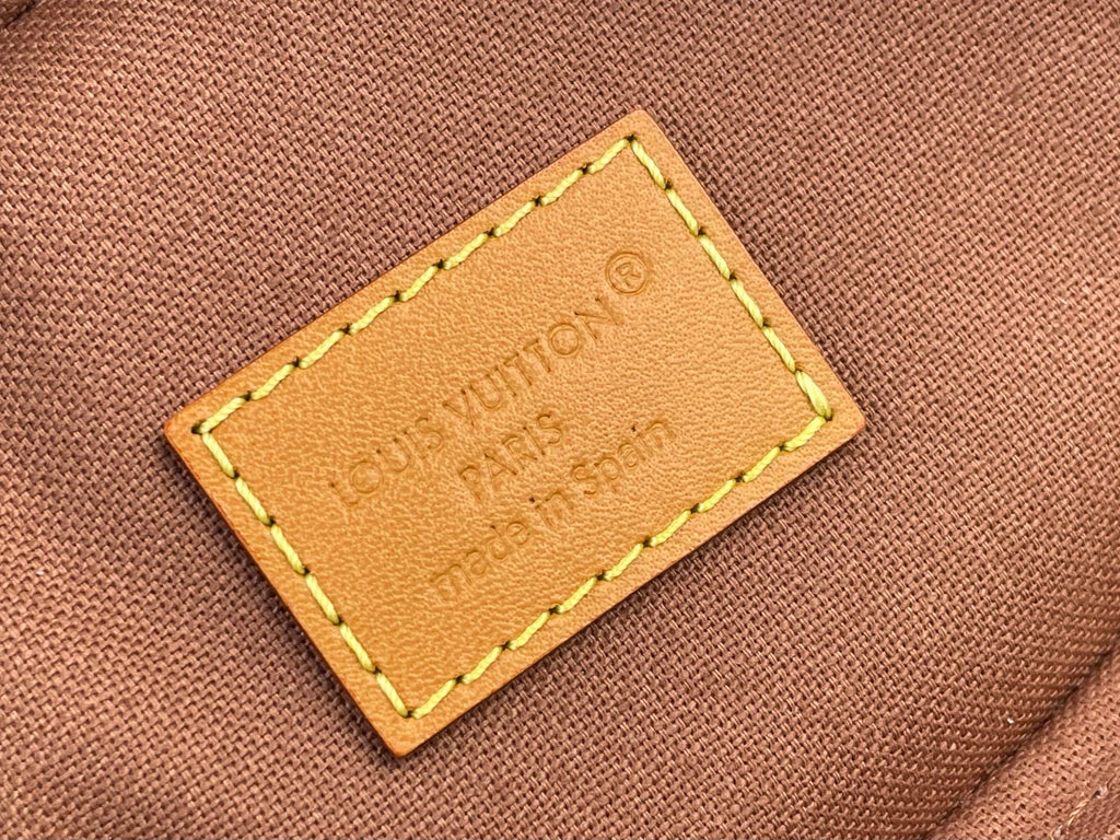 Louis Vuitton bag leather logo patch with yellow edge stitching on brown canvas