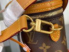 Gold D-ring and zipper pull on tan-and-brown monogram bucket bag