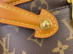 Round gold snap button on tan leather tab of Louis Vuitton monogram bag