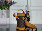Louis Vuitton monogram bucket bag with tan shoulder strap and hanging charm details