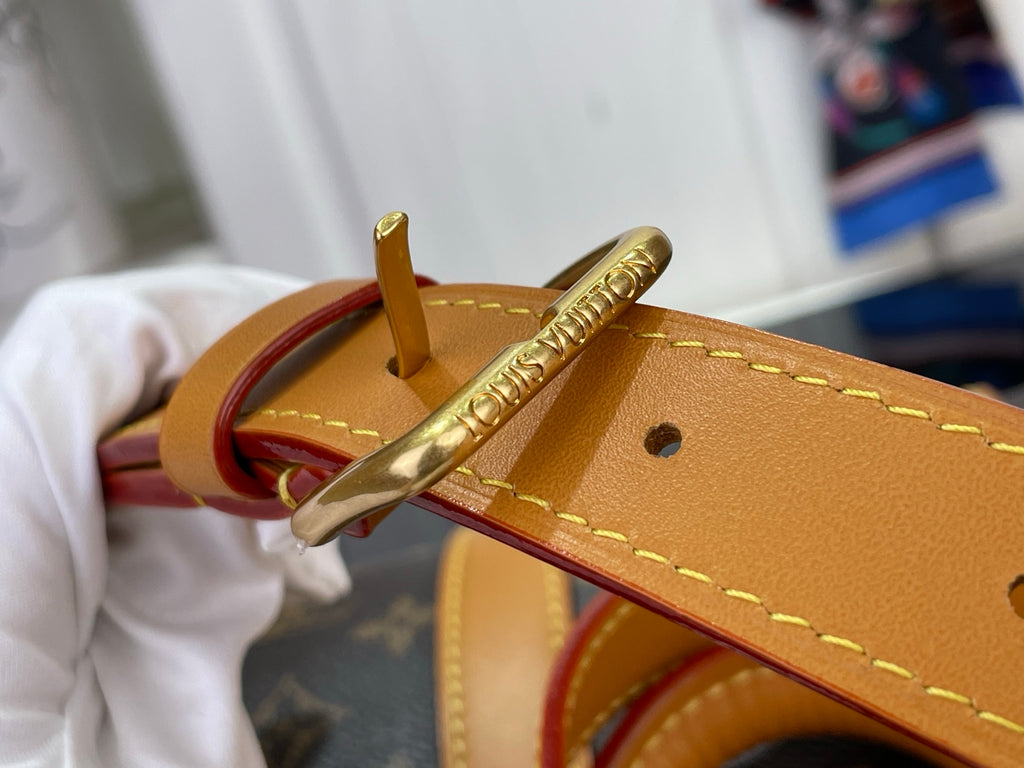 Tan leather belt strap with gold buckle on monogram canvas duffel