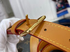 Tan leather belt strap with gold buckle on monogram canvas duffel