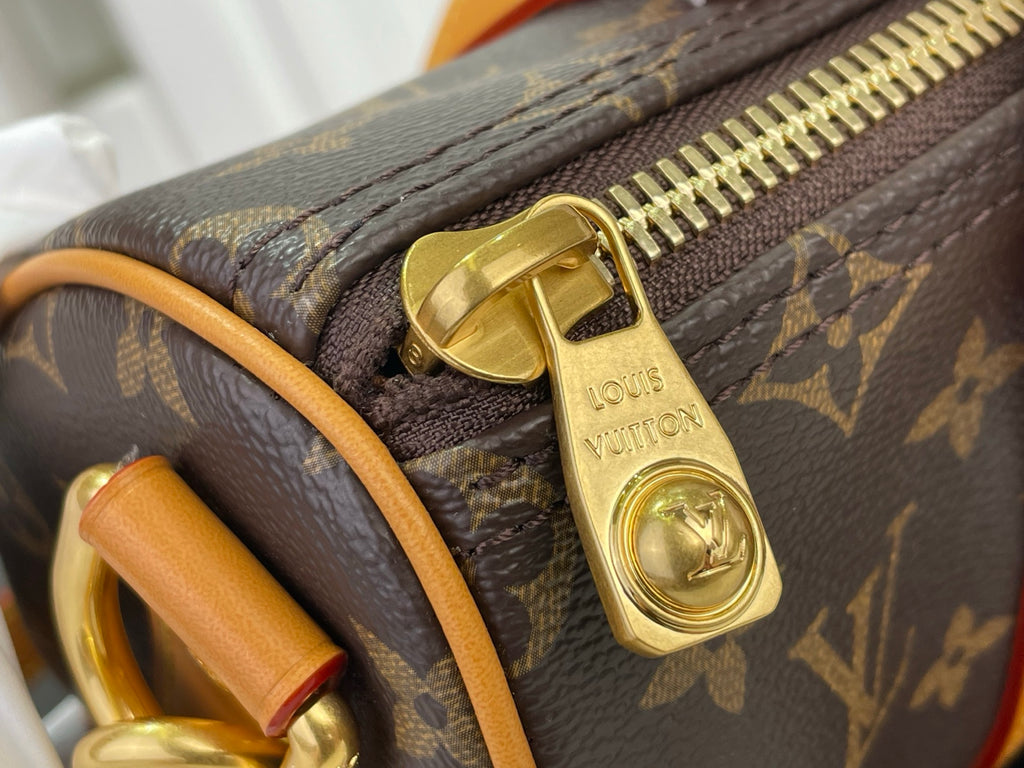 Zipper pull and lock charm on monogram canvas duffel with tan leather strap