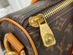 Zipper pull and lock charm on monogram canvas duffel with tan leather strap