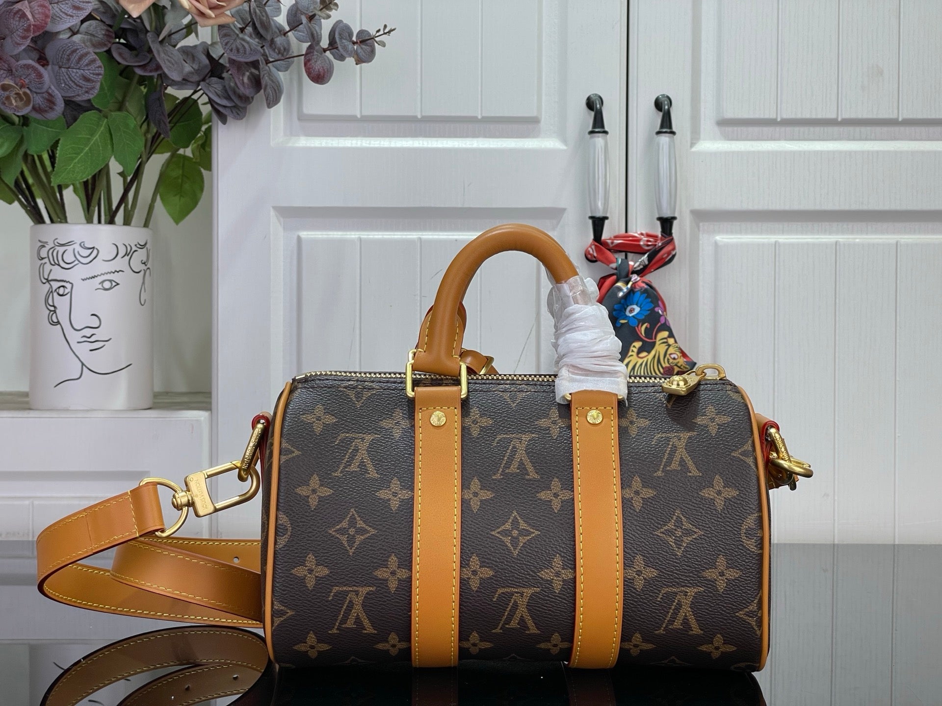 Monogram canvas duffel bag with tan leather straps and top handles